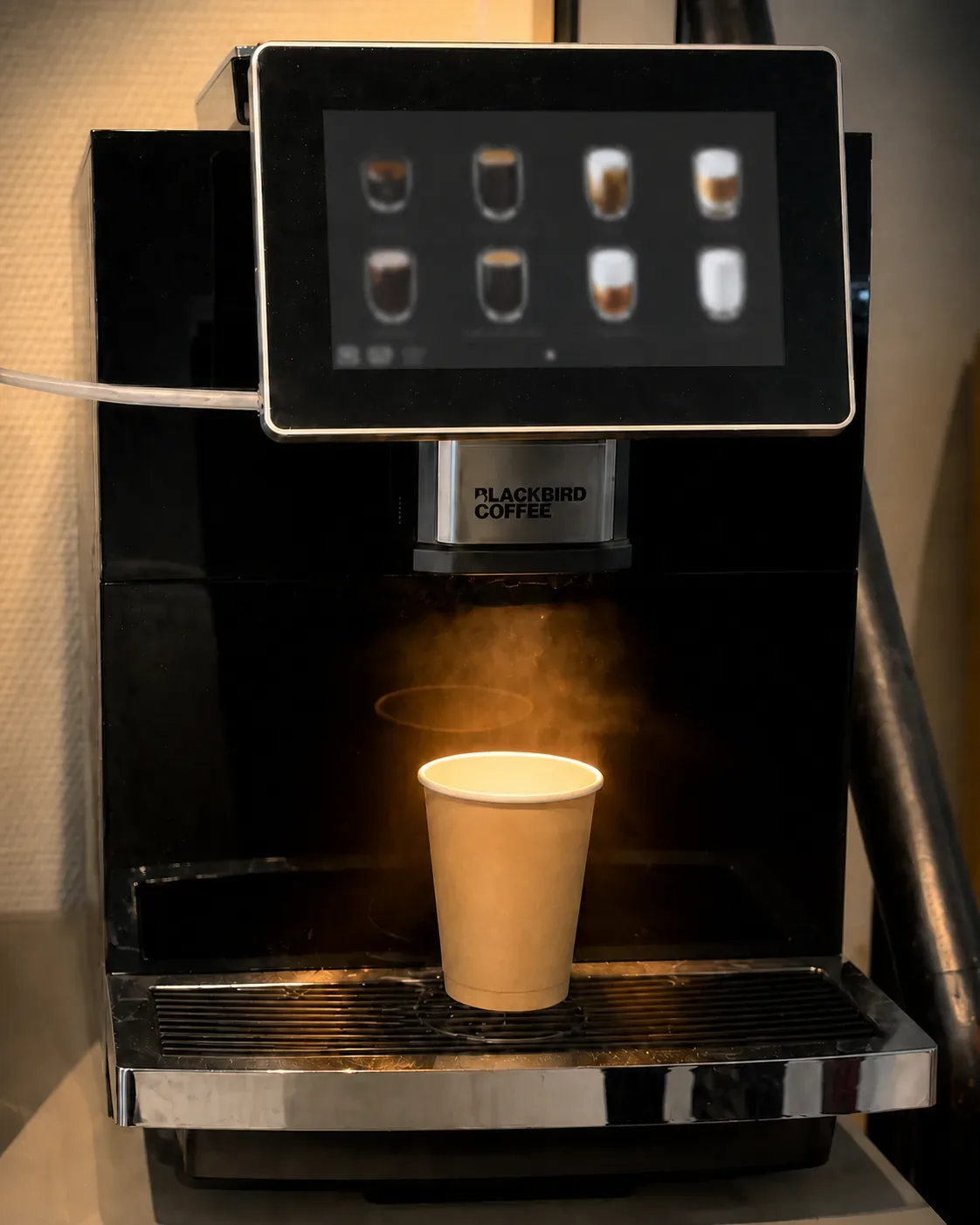 Kaffemaskine, damp og et to-go-krus med friskbrygget kaffe hos Hafniakiosken